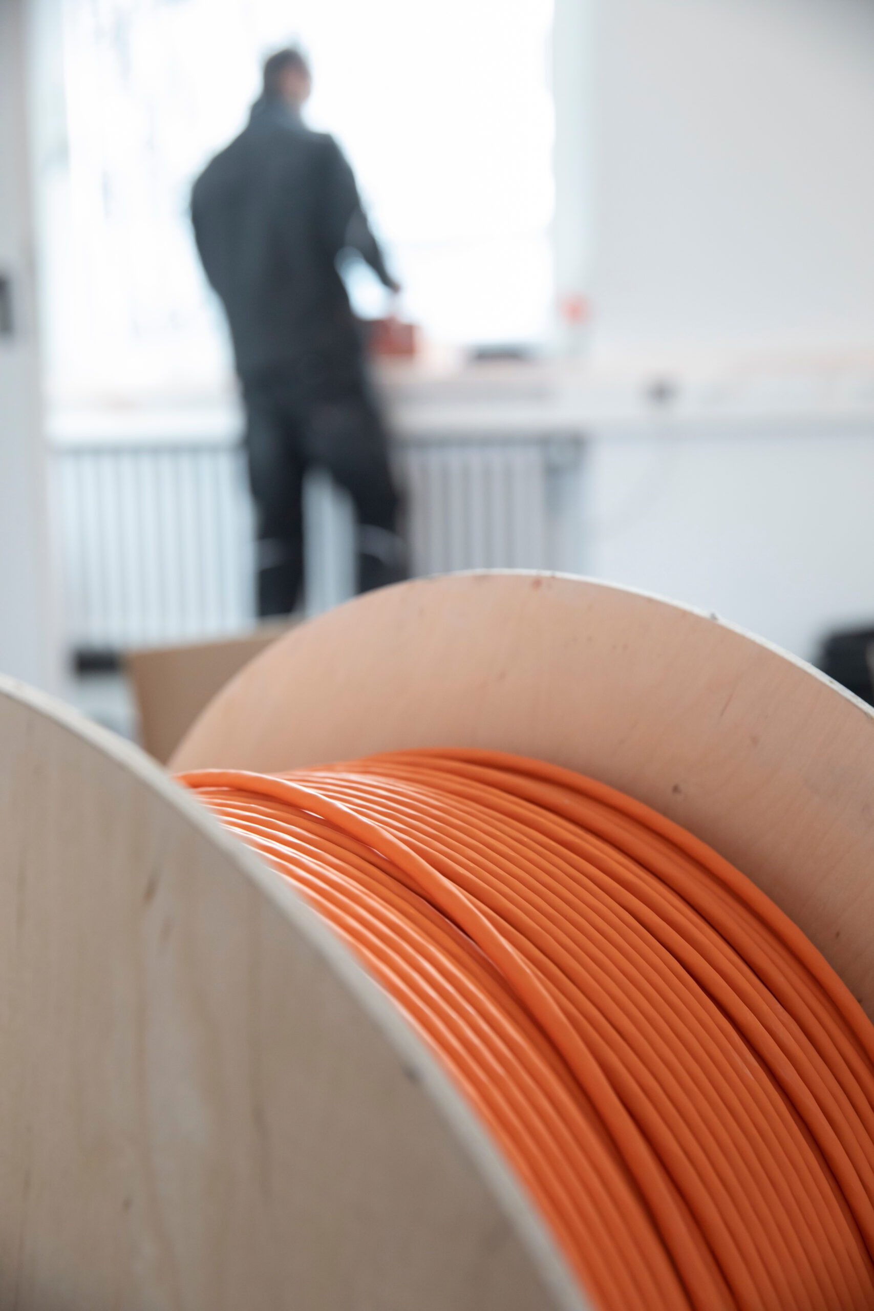 Orangenes Twisted-Pair Kabel auf Trommel vor Installation in Büroumgebung