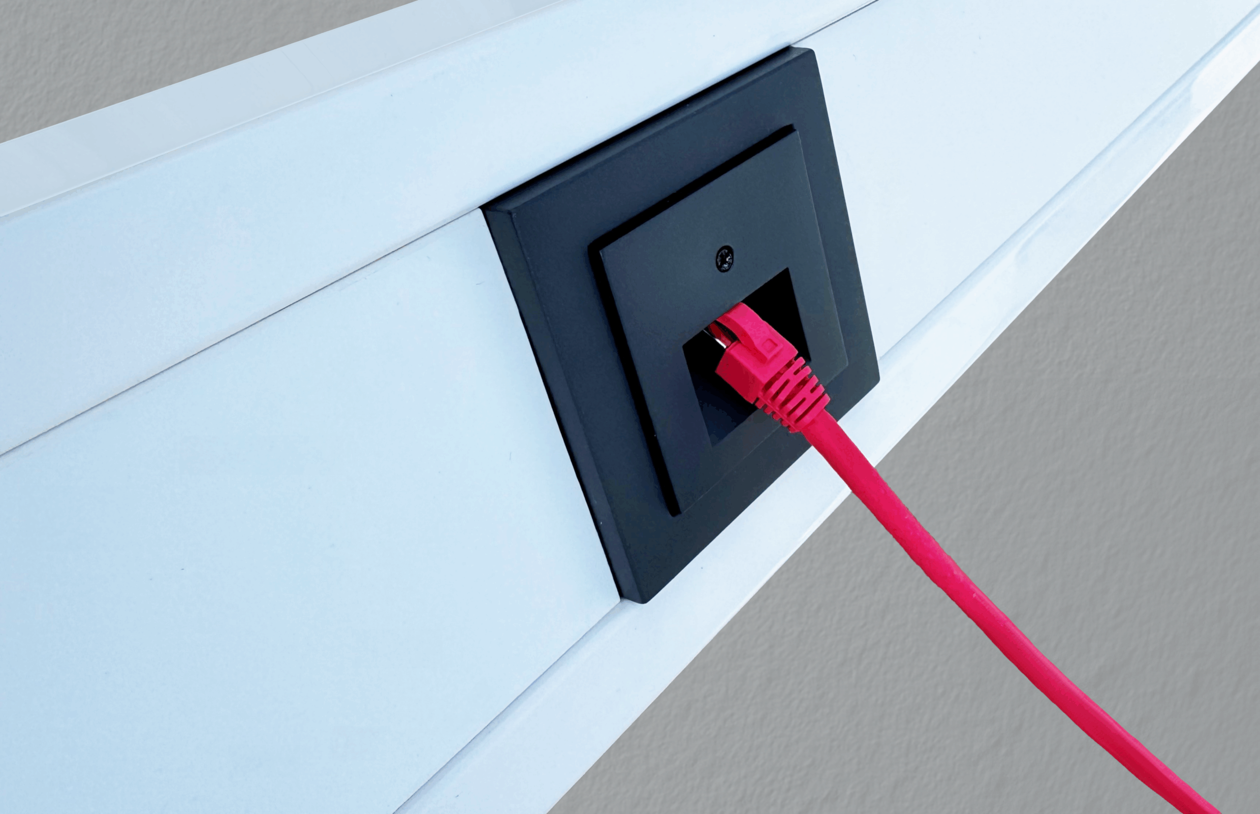 Kanal mit UAE Tragrahmen unter Gira System S55 Zentralplatte und Abdeckrahmen Anthrazit, rotes Patchkabel