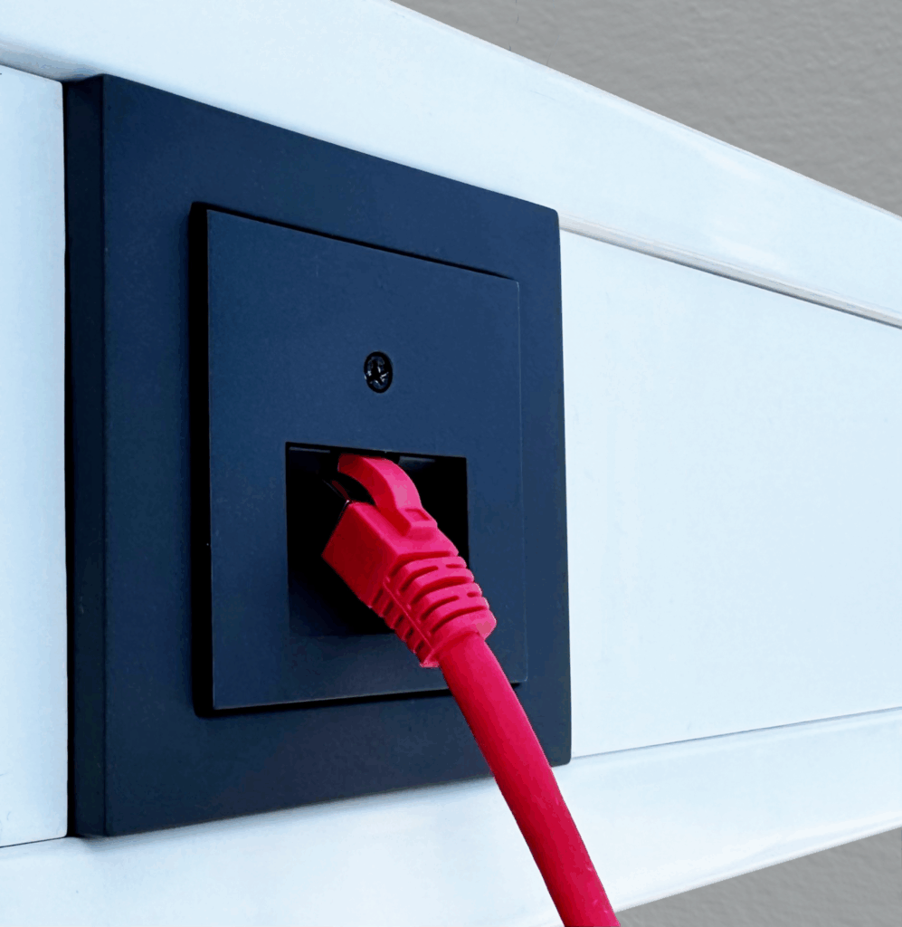 UAE Tragrahmen im Kanal mit Gira System S55 Zentralplatte und Abdeckrahmen Anthrazit, rotes Patchkabel gesteckt